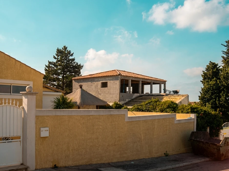 l'homme isole le toit et le plafond de la maison avec de la laine de verre